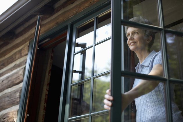 Senior woman looking through open window