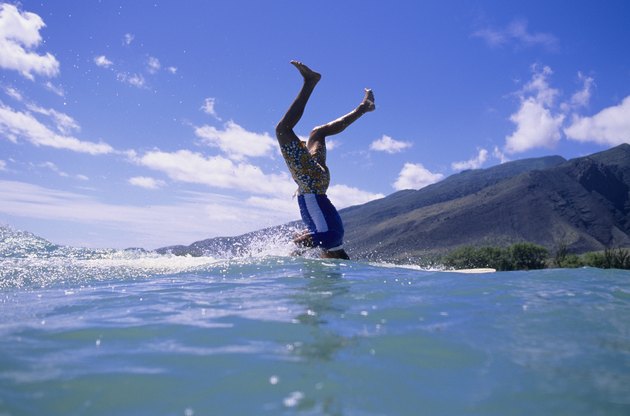Man standing on head on surfboard at ocean