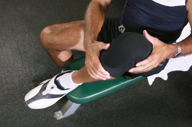Senior man in gym wearing knee strap, lifting knee, overhead view