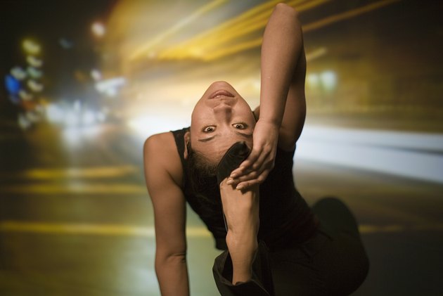 Young woman stretching, street scene projected in background