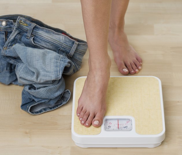 Woman stepping on scale, low section, close-up