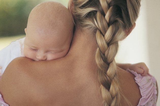Rear View of a Mother Holding Her Sleeping Newborn Baby