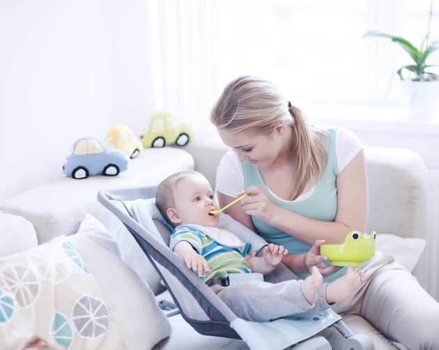 Teenage girl feeding baby boy