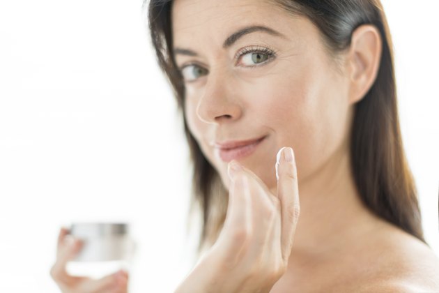 Woman in her forties applying face cream