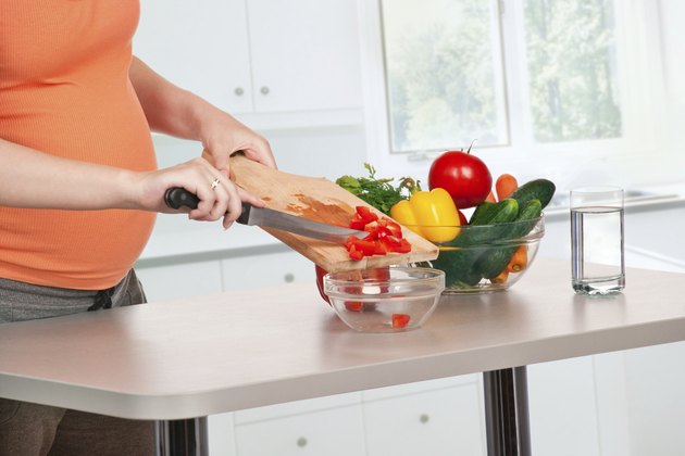 pregnant woman cooking at kitchen