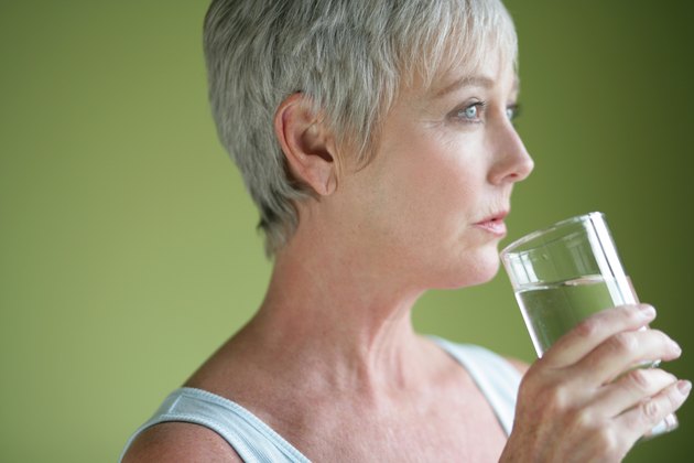 Mature adult with glass of water.
