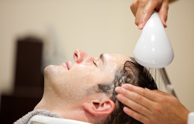Close-up of a young man having his hair washed