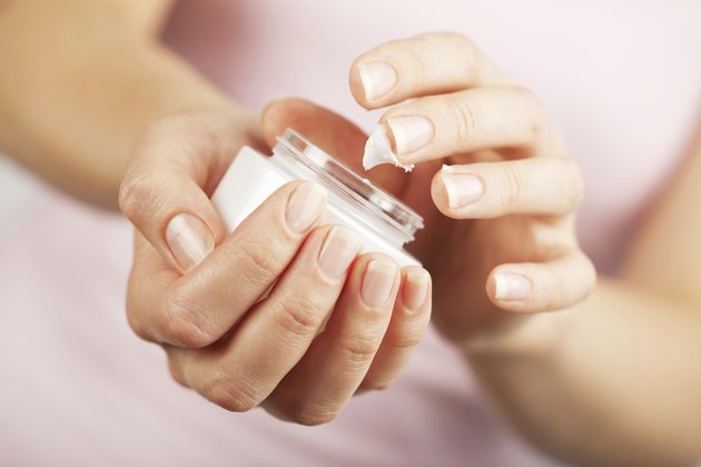 beautiful woman hands applying cream