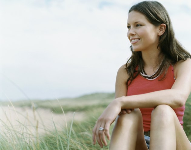 Smiling young Woman Sitting in Dune Grass