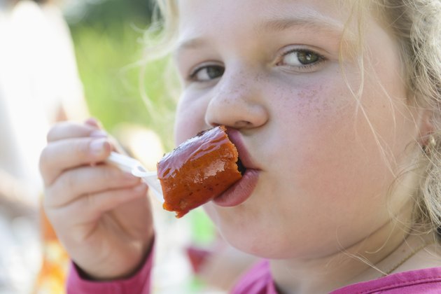 Young girl eating sausage