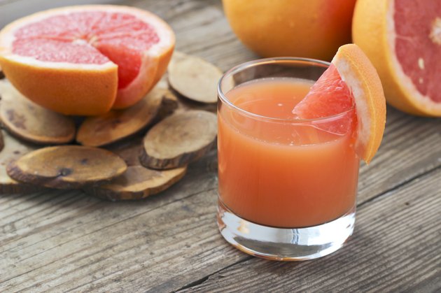 Grapefruit juice and slices on a wooden table