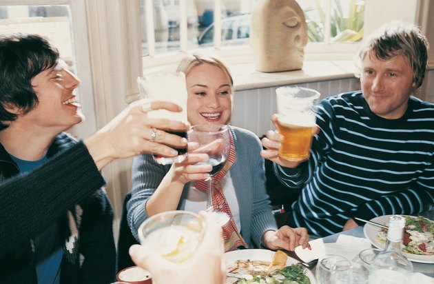 Friends Lifting their Glasses and Celebrating in a Restaurant
