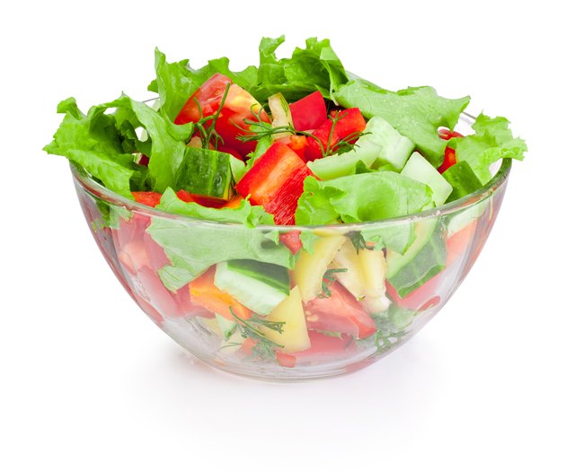 Fresh vegetable salad in glass bowl isolated on white background
