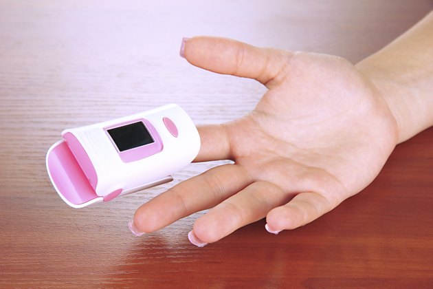 Pulseoximeter used to measure pulse rate on wooden background