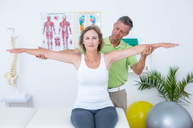 Doctor stretching his patients arms