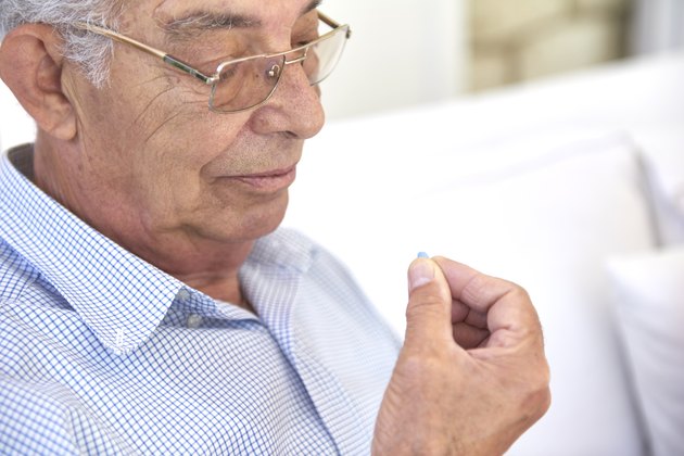 Old man taking pill