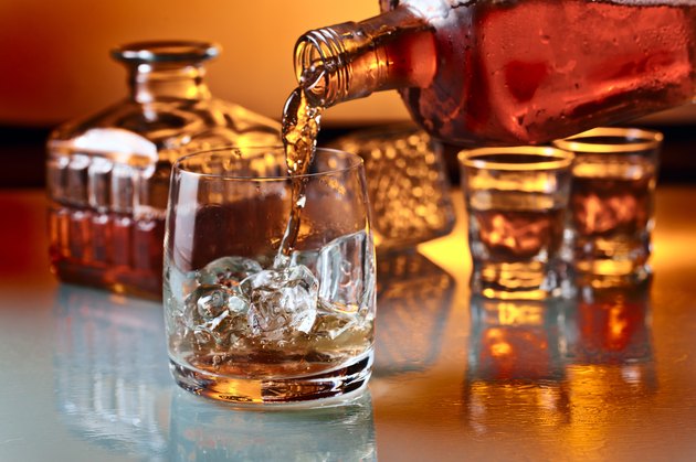 glass with whiskey and ice on a glass table