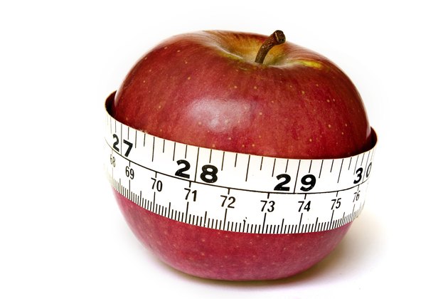 A stock photograph of an apple with a measuring tape around it.