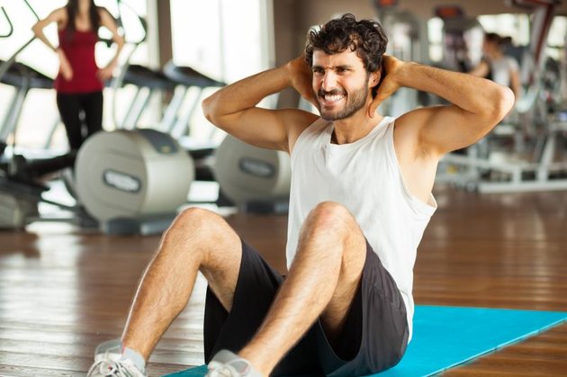 young man making abdominal exercises in gym