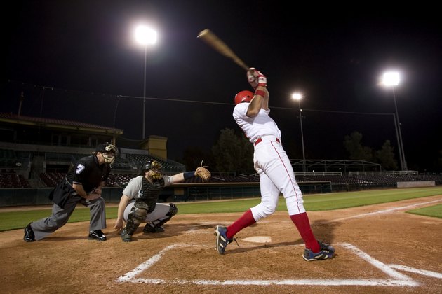 USA, California, San Bernardino, baseball players with batter swinging