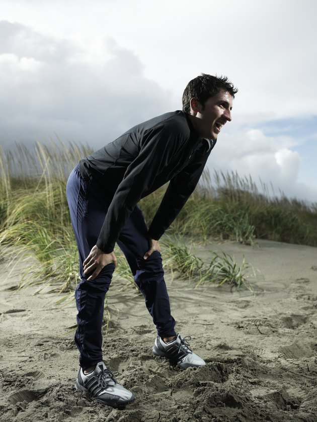 Man bending over on beach