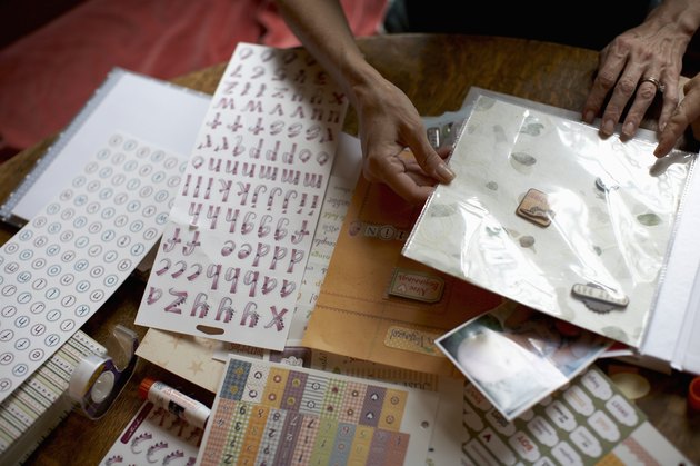Two women assembling scrapbook, mid section, high angle view