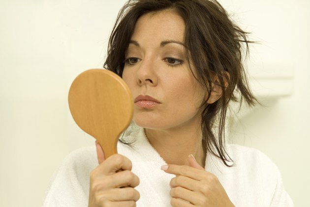 Woman looking in mirror, close-up