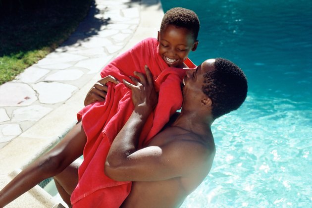 Father and son playing by pool