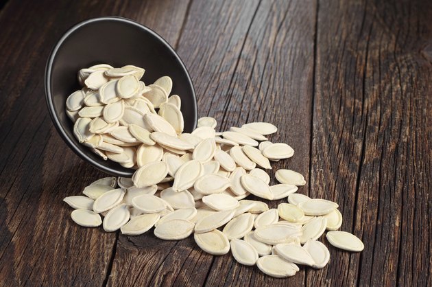 Pumpkin seeds in bowl and near