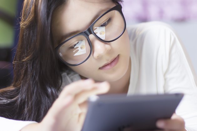 Woman using a tablet at bedroom