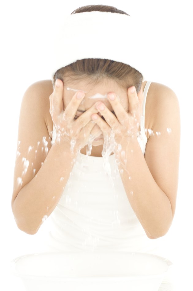 Woman rinsing face with water