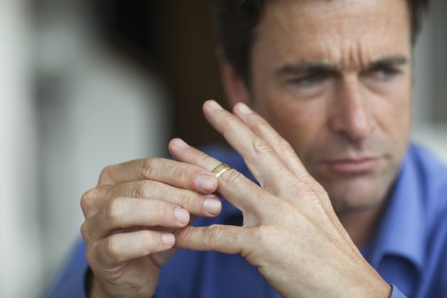 Mature man toying with gold wedding ring on finger