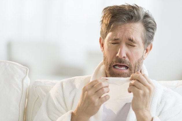 Man Sneezing Into Tissue