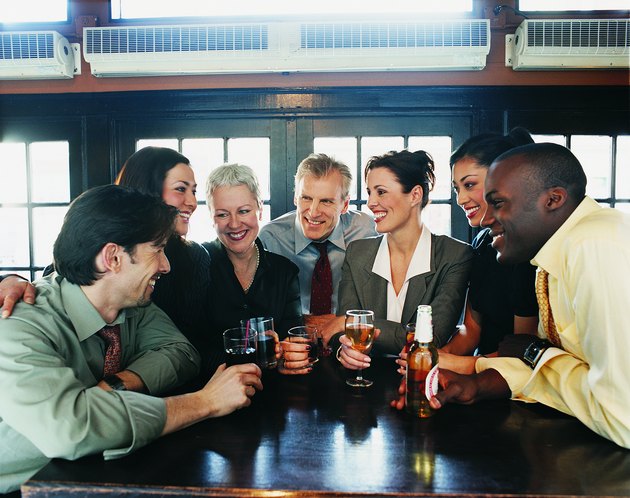 Businessmen and Businesswomen Work Colleagues Enjoying a Drink in a Bar