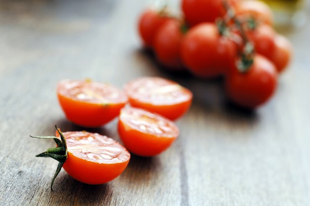 mini sliced halved cherry tomatoes against oak background