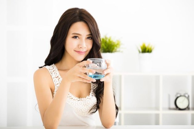 relaxed young smiling woman drinking clean water