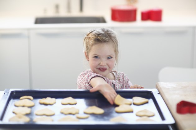 Girl with cookie dough on baking tray