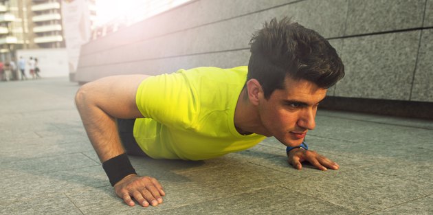 Picture of young handsome athletic man doing pushups