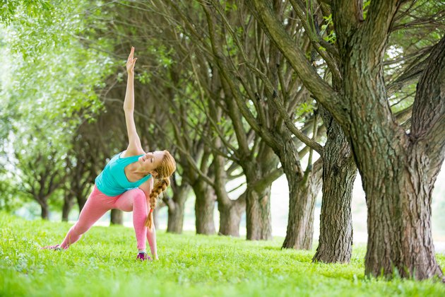 Young slim lady training in the park.