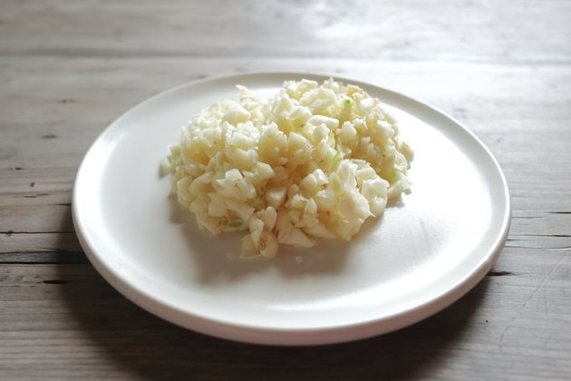 ground fresh garlic on white plate with wood background