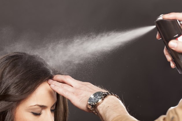 Hairdresser applying hairspray