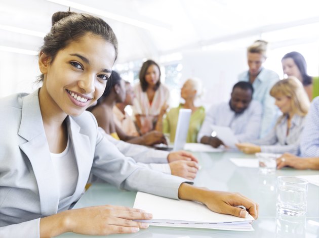 Hispanic business woman in conference with associates