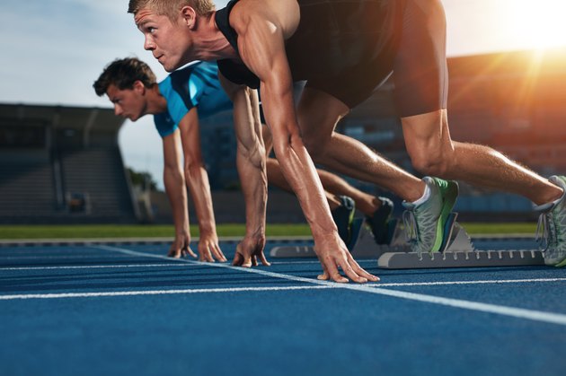 Fit athlete running race in athletics racetrack