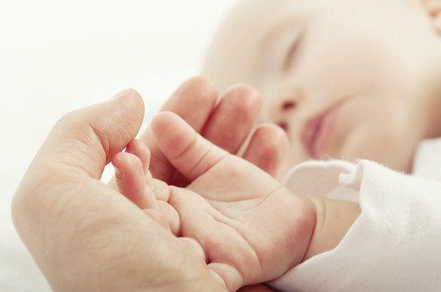 sleeping baby in hand of mother