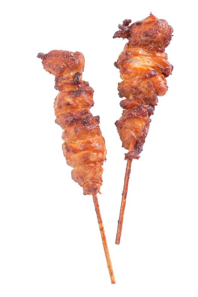Chicken satay – grilled chicken skewers isolated on white background
