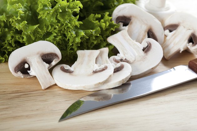 Mushrooms with knife on chopping board