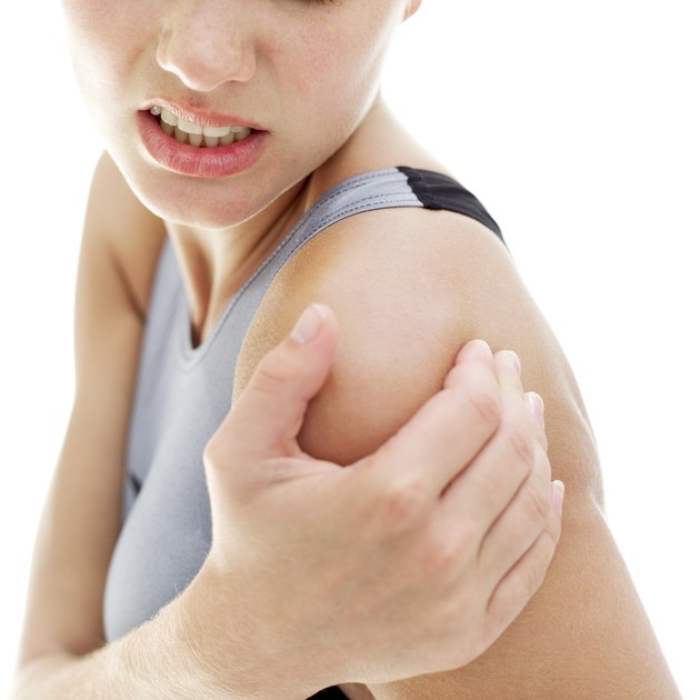 young woman holding her shoulder in pain