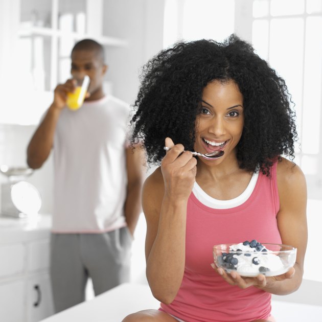 Portrait of a young woman eating ice cream and fruit from a bowl