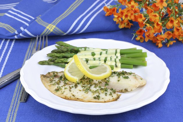 Healthy, fresh tilapia fillets with asparagus and Hollandaise sa