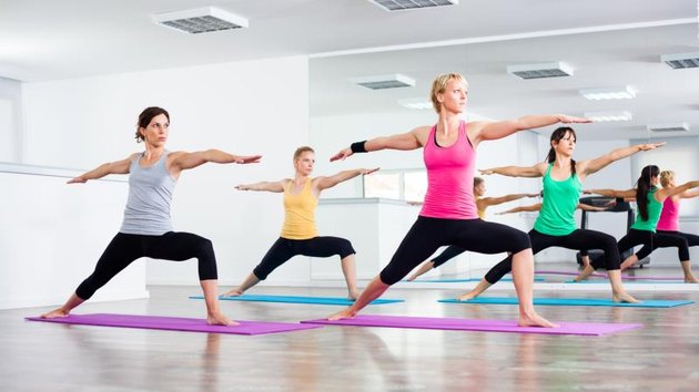 Four girls practicing yoga, Yoga - Virabhadrasana/Warrior pose